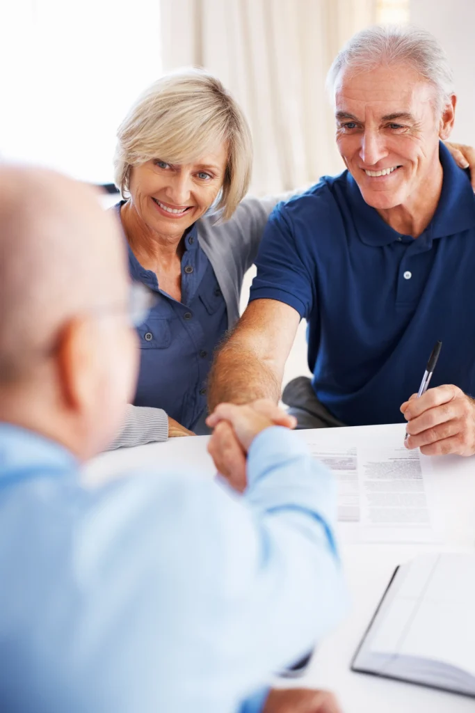 Happy senior couple sealing a deal with their personal financial planner